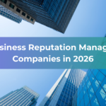 Looking up at tall modern skyscrapers against a blue sky, this image features the text Top Business Reputation Management Companies in 2026 over a green and purple gradient banner, highlighting the importance of business reputation management in today’s corporate landscape.